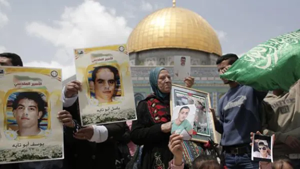 Palestinian protesters hold portraits of prisoners during a rally marking the Palestinian Prisoner Day at the al-Aqsa Mosque compound in Jerusalem. (AFP)