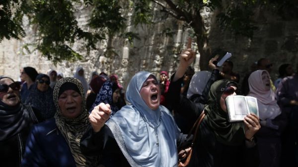 Palestinian women chant slogans outside the Lion's Gate, a main entrance to Al-Aqsa mosque compound (AFP)