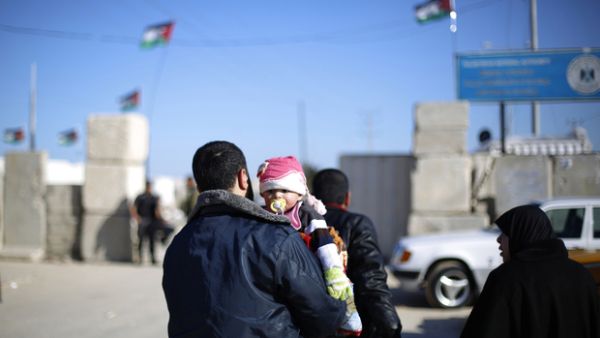 Man holds his child as they wait to cross at Erez between Gaza and Israel earlier this year. (AFP/File) 