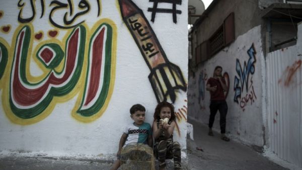 Palestinian children play with chicks in the streets in Jabalia refugee camp, in the northern Gaza Strip, on May 14, 2017 one day before the marking of the 69th anniversary of the "Nakba." (AFP/Mahmud Hams)