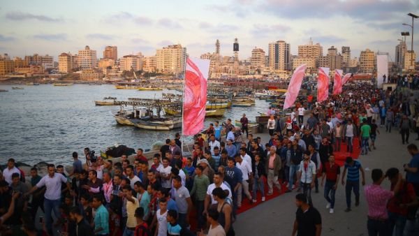 Palestinians walk on the red carpet during a film festival showcasing films focusing on human rights, in Gaza City on May 12, 2017. (AFP/Mohammed Abed)