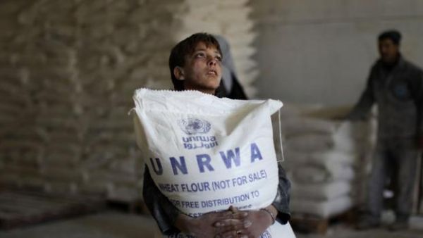 A Palestinian child in Gaza holds a bag of flour distributed by UNRWA. (AFP/File)