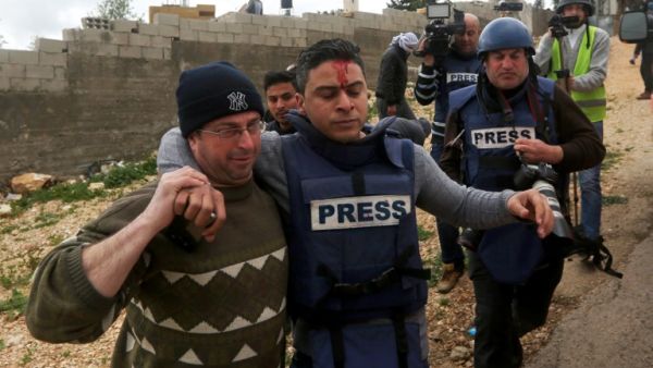 A Palestinian TV correspondent is transported away from clashes following a weekly demonstration against the expropriation of Palestinian land by Israel in the village of Kfar Qaddum, near Nablus, in the occupied West Bank on March 3, 2017. (AFP/Jaafar Ashtiyeh)