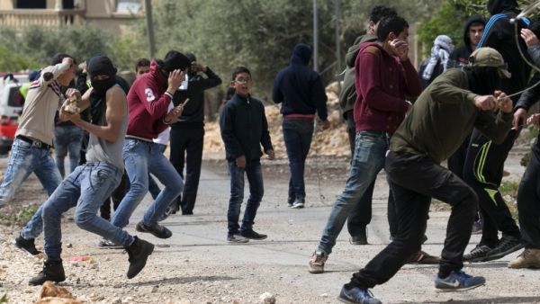 Palestinian protesters take cover during clashes with Israeli security forces following a weekly demonstration against the expropriation of Palestinian land by Israel in the village of Kfar Qaddum, near Nablus, in the occupied West Bank on April 14, 2017. (AFP/Jaafar Ashtiyeh)