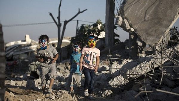 Palestinian children play in the rubble of buildings, reportedly destroyed during the 50-day war between Israel and Hamas militants. (AFP / MOHAMMED ABED)