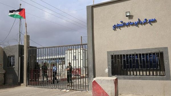 Palestinian security forces loyal to the Palestinian Authority stand at the gate of the Kerem Shalom crossing. (AFP/ SAID KHATIB)