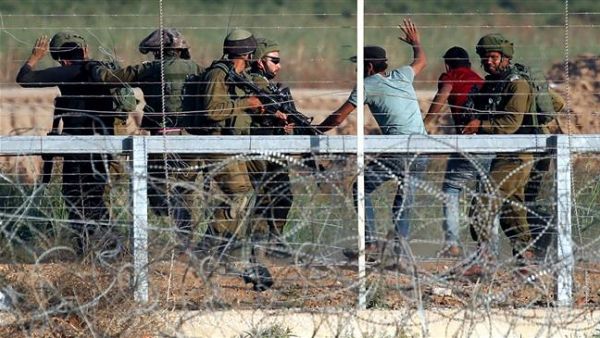 Israeli soldiers arrest Palestinians who tried to approach the Gaza fence during clashes east of Gaza City on May 15, 2018. (AFP/ File Photo)