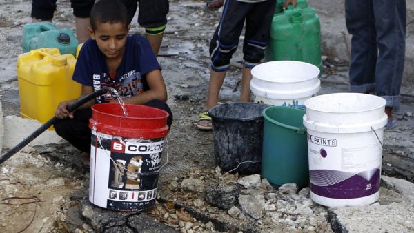 Palestinians collect water from a broken pipe (Mohammed Abed/AFP)