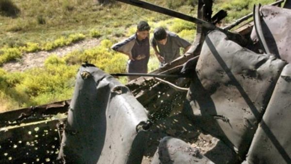 KHALIS : Iraqi boys looks at a bus that was hit by a roadside bomb 29 May 2006 in the town of Khalis, northeast of Baghdad. Eleven people were killed 11 others were wounded in the attack. 