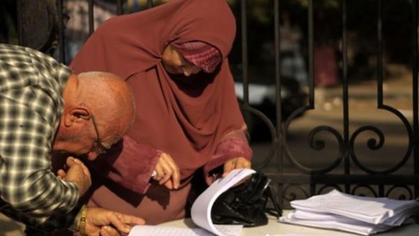 EGYPT, Cairo : An Egyptian man checks for the name of his wife at the entrance of a polling station in Cairo on November 28, 2010, as polls opened across Egypt for a parliamentary election expected to strengthen the ruling party's grip in the most populous Arab nation but marred by a crackdown on the Islamist opposition.