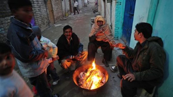 Islamabad : Pakistani Christian warm themselves around a fire in the slum area of Islamabad