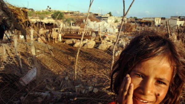A young Palestinian girl stands in front of her Bedouin tent slum, in the seaside al-Mawasi area.