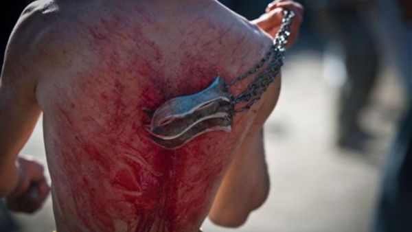 An Afghan Shiite Muslim man beats himself with chains and blades during a Muslim ritual on the last day of Ashura celebrations in the streets of Kabul on December 16, 2010. 
