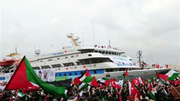 People wave Palestinian and Turkish flags as they welcome the Mavi Marmara ship at Istanbul's Sarayburnu port on December 26, 2010. The Turkish ferry which was the target of a deadly raid by Israeli commandos when it tried to deliver aid to Gaza received a rapturous welcome from thousands on Sunday as it arrived back in Istanbul. 