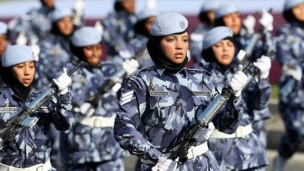 Qatari women and members of the armed forces take part in a military parade during National Day celebrations in Doha on December 18, 2010