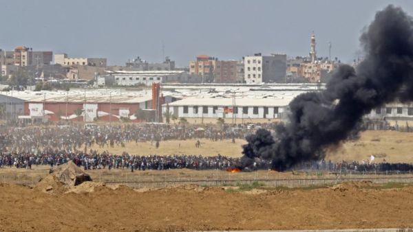 A picture taken on May 14, 2018 from the southern Israeli kibbutz of Nahal Oz across the border with the Gaza Strip shows Palestinian protestors gathering along the border fence with Israel/AFP