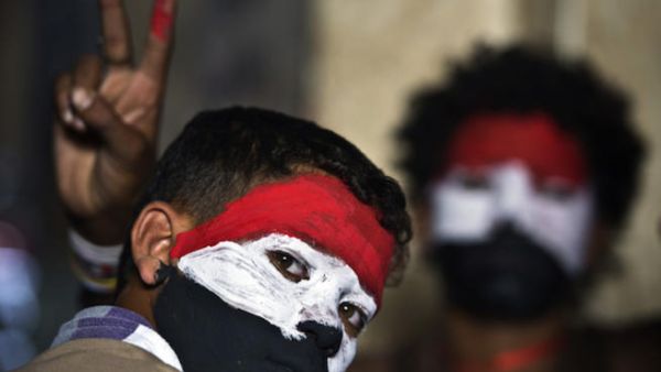 Egyptian youth with their faces painted in the colours of the national flag look on as opponents of Egyptian President Mohamed Morsi protest calling for his ouster at Cairo's landmark Tahrir Square (Source: AFP/KHALED DESOUKI)