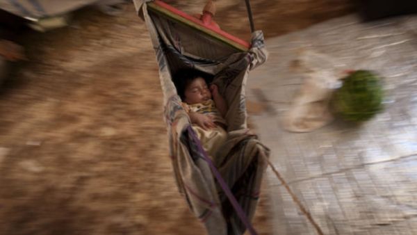 A Syrian refugee baby sleeps in a hammock at the Bab al-Salam refugee camp in Syria's northern city of Azaz on July 15, 2013. (Source: AFP/JM LOPEZ)