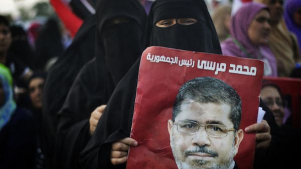 An Egyptian woman holds the portrait of deposed president Mohammed Morsi during a rally in his support outside Rabaa al-Adawiya mosque on July 15, 2013 in Cairo. (Source: AFP/GIANLUIGI GUERCIA)