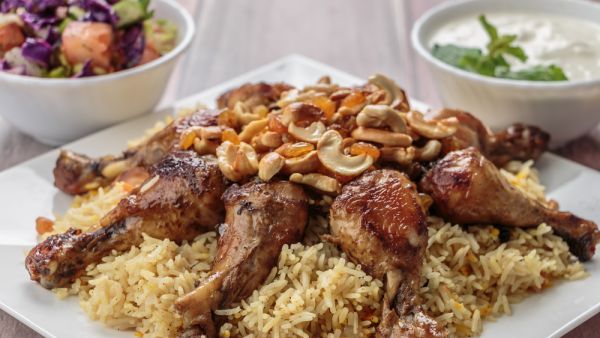 Mandi, a traditional rice dish popular in the Gulf, is served with chicken or lamb and topped with cashews and dried fruit. (Shutterstock)