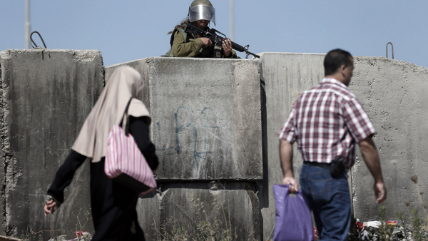 An Israeli soldier stands guard at Qalandiya checkpoint, where the two Palestinian siblings, Maram Abu Ismayil, 23, and Ibrahim Salah Tahah, 16, were shot dead Wednesday. (photo: Thomas Coex/AFP)