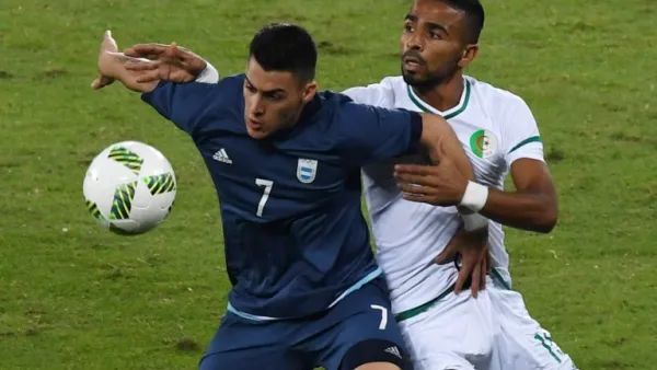 Argentina player Cristian Pavon (L) vies for the ball with Algeria player Houari Ferhani during the Rio 2016 Olympic Games men's First Round Group D football match, at the Olympic Stadium in Rio de Janeiro on August 7, 2016.
VANDERLEI ALMEIDA / AFP