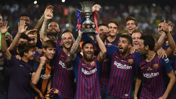 Barcelona's Argentinian forward Lionel Messi (C) carries the cup as they celebrate at the end of the Spanish Super Cup final between Sevilla FC and FC Barcelona at Ibn Batouta Stadium in the Moroccan city of Tangiers on August 12, 2018.
FADEL SENNA / AFP