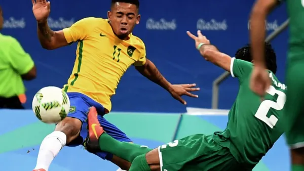 Brazil's player Gabriel Jesus (L) and Iraq's Dhurgham Ismael vie for the ball during their Rio 2016 Olympic Games Men's First Round Group A football match, at the Mane Garrincha Stadium in Brasilia on August 7, 2016.
EVARISTO SA / AFP