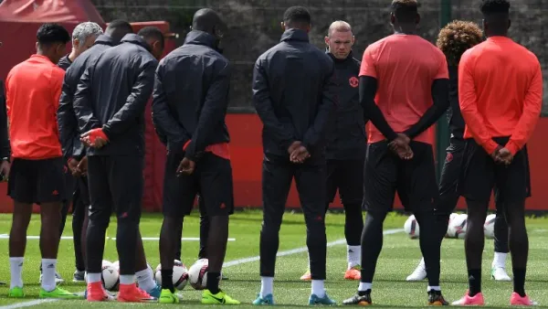 Manchester United's English striker Wayne Rooney (4R) stands with teammates as they observe a minute's silence for the victims of yesterday's terror attack at the Ariana Grande concert at the Manchester Arena, during a team training session at the club's training complex near Carrington, west of Manchester in north west England on May 23, 2017, ahead of their UEFA Europa League final football match against Ajax.
Paul ELLIS / AFP