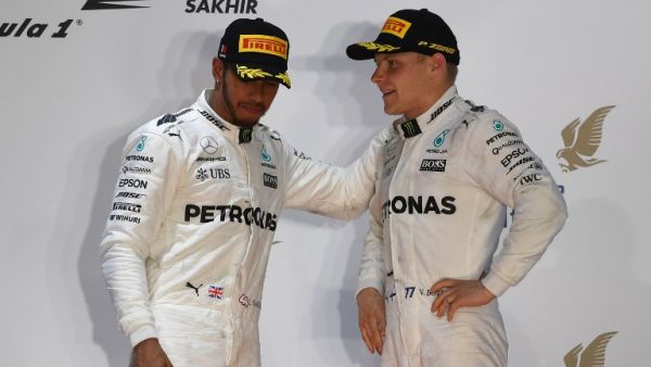 Mercedes' British driver Lewis Hamilton (L) and Mercedes' Finnish driver Valtteri Bottas stand on the podium after Ferrari's German driver Sebastian Vettel won the Bahrain Formula One Grand Prix at the Sakhir circuit in Manama on April 16, 2017.
ANDREJ ISAKOVIC / AFP