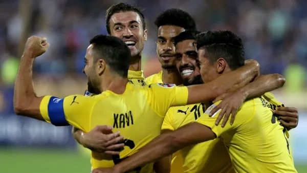 Al-Sadd's forward Baghdad Bounedjah (1st-R) celebrates after scoring a goal with his teammates, Spanish midfielders Xavi Hernandez (1st-L) and Gabi (2nd-L) during the AFC Champions League football match Al-Sadd (Qatar) vs Esteghlal FC (Iran) at the Azadi stadium in Tehran on August 27, 2018.
ATTA KENARE / AFP