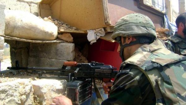 A handout picture released by the Syrian Arab News Agency (SANA) on May 20, 2013, allegedly shows a Syrian soldier scanning the area for hostiles in the the town of Qusayr in Homs province (SANA / AFP)