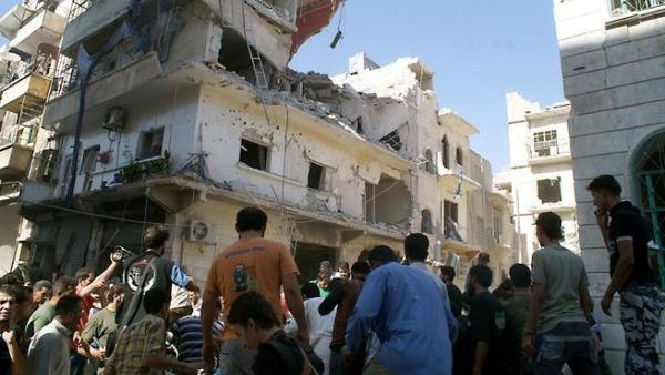 Rescuers and neighboors gather at the scene after a rocket slammed into the side of a residential building in the northern city of Aleppo, on June 29 (Jalal Al-Halabi / AFP)