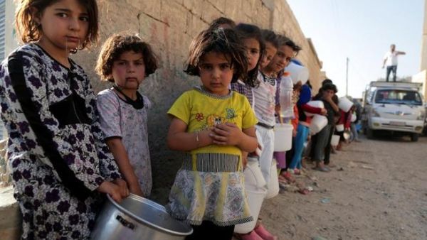 SYRIA, RAQQA : Syrian children wait in line to collect a free “Iftar” meal in the northern city of Raqqa during the Muslim holy month of Ramadan on July 14, 2013. (AFP PHOTO/MEZAR MATAR) 