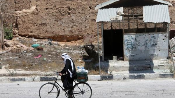 SYRIA, QUSAYR : A Syrian resident rides his bicycle on August 1, 2013 in a street of the city of Qusayr, in Syria's central Homs province. AFP PHOTO/JOSEPH EID