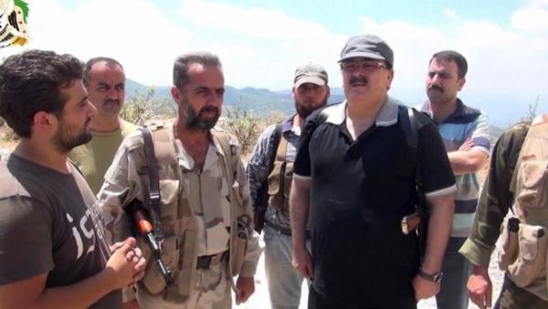 SYRIA, Latakia : An image grab taken from a video published on the Youtube account Jableh1990 on August 11, 2013 allegedly shows Syrian rebel leader General Salim Idris (C-R) talking to rebel fighters in the outskirts of Latakia.  AFP PHOTO/YOUTUBE