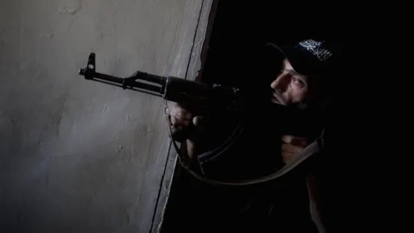 A rebel fighter points his gun towards pro-government forces' positions during clashes in the Salaheddine district of the northern Syrian city of Aleppo (JM Lopez / AFP)