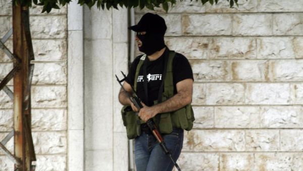 A masked gunman opposed to the Shiite party Hezbollah, stands in the southern town of Sidon's eastern suburb of Abra, on June 18, 2013. (File photo / AFP)