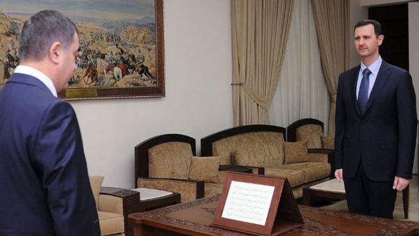 A handout picture released by the Syrian Arab News Agency (SANA) shows Syrian President Bashar al-Assad  with the newly-appointed governor of Syria's province of Quneitra Maen Salah-Eddin Ali, after he was sworn in on July 18, 2013. (AFP PHOTO / HO / SANA)