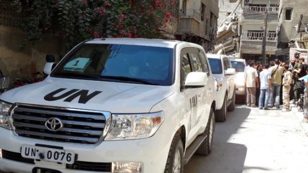 SYRIA, DAMASCUS : Syrians gather near vehicles of the United Nations (UN) arms experts as they inspect a site suspected of being hit by a deadly chemical weapons attack last week on August 28, 2013 in the Eastern Ghouta area on the northeastern outskirts of Damascus. AFP PHOTO /MOHAMED ABDULLAH