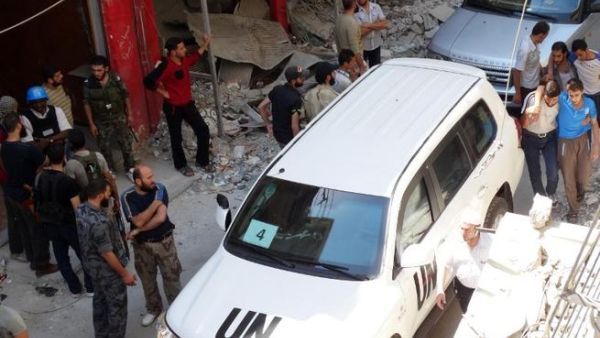 SYRIA, DAMASCUS : Syrians gather near a vehicle of the United Nations (UN) arms experts as they inspect a site suspected of being hit by a deadly chemical weapons attack last week on August 28, 2013 in the Eastern Ghouta area on the northeastern outskirts of Damascus. AFP PHOTO /MOHAMED ABDULLAH