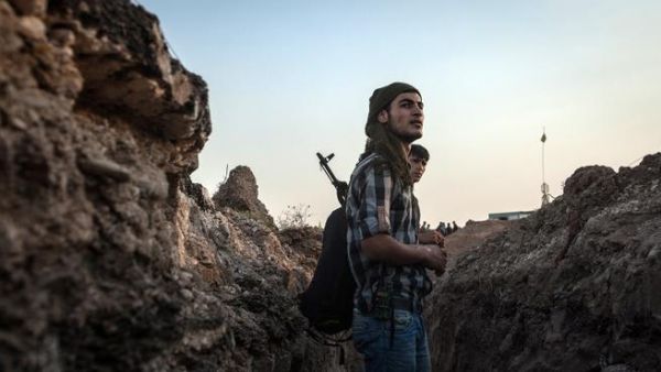 SYRIA, DERIK : Fighters of the Kurdish of the Committees for the Protection of the Kurdish People (YPG) stand in a trench on August 28, 2013 about 30 kms south of the Kurdish town of Derik (aka al-Malikiyah in Arabic), in northeastern Hasakeh governorate, on the border with Turkey and Iraq. AFP PHOTO ALICE MARTINS