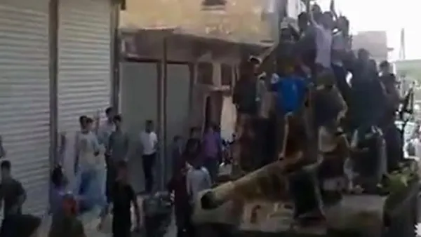 حلبيون يعتلون ظهر دبابة استولىعليها مقاتلون من المعارضة/أ.ف.ب