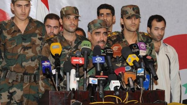 مقدم سوري مع مجموعة من العسكريين خلال مؤتمر صحافي في دمشق