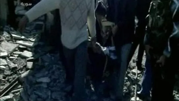 شخاص يحملون جثة احد ضحايا تفجيري دمشق يوم الجمعة. 