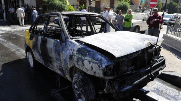 A handout picture released by the official Syrian Arab News Agency (SANA) on October 12, 2013 shows a burnt car after SANA said, two mortar rounds slammed into a  neighbourhood of the Syrian capital Damascus. (Image credit: AFP)