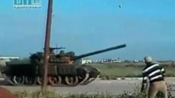 متظاهر سوري يقذف دبابة للجيش بالحجارة