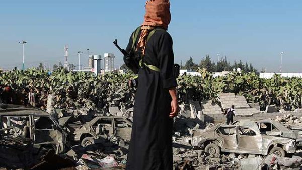 A Yemeni man observes the damage following a Saudi-led coalition airstrike near Sanaa's airport.  (AFP/File)