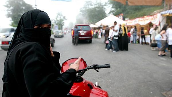 A veiled woman takes her motor bike for a spin.  Though women are banned from driving in his home country, Saudi Prince Fahad al-Saud has developed "Saudi Girls Revolution," a post-apocalyptic action game featuring female bikers.  (AFP/Joseph Barrak)