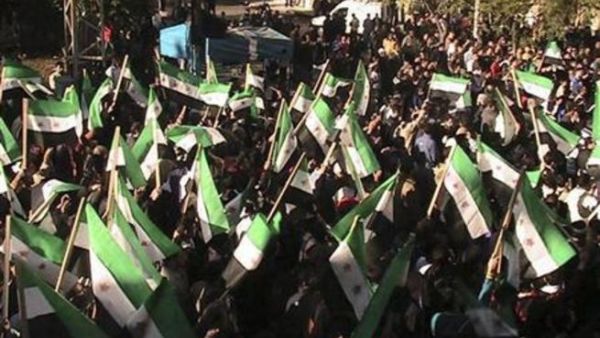 متظاهرون ضد الرئيس السوري بشار الاسد يلوحون بالاعلام السورية القديمة خلال مسيرة بالقرب من درعا يوم الاحد. 